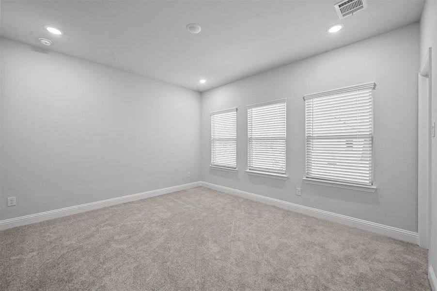Spare room featuring light colored carpet and recessed lighting