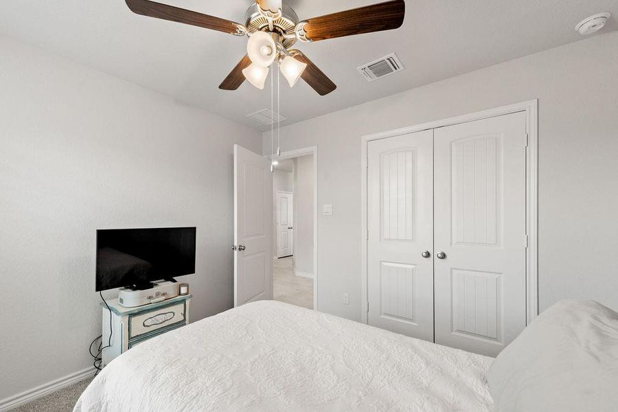 Bedroom featuring ceiling fan, a closet, and carpet