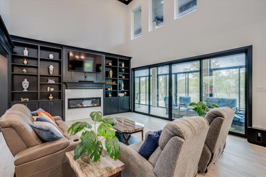 Living area with a glass covered fireplace and light tile finished floors