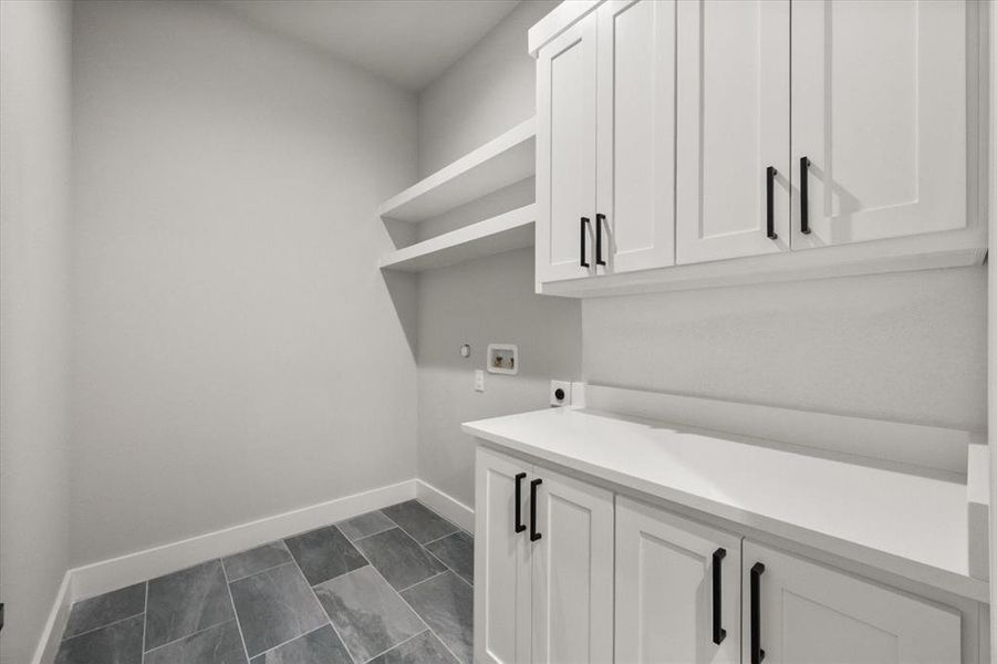 Large walk-in laundry room with built in cabinets and storage shelves Large walk-in laundry room with built in cabinets and storage shelves