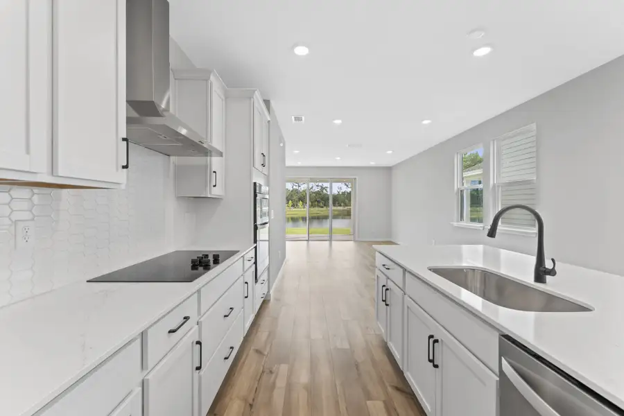 Miramar Floorplan Lot 81 Kitchen with White Cabinets and Black Hardware at Concourse Crossing in Fernandina Beach