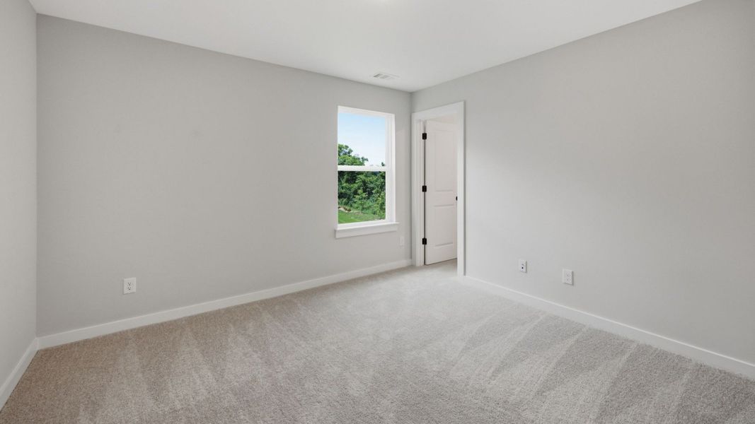Secondary bedroom with carpet and window