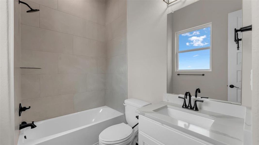 Smooth stone countertops and contemporary dark hardware elevate this modern bathroom design. Smooth stone countertops and contemporary dark hardware elevate this modern bathroom design.