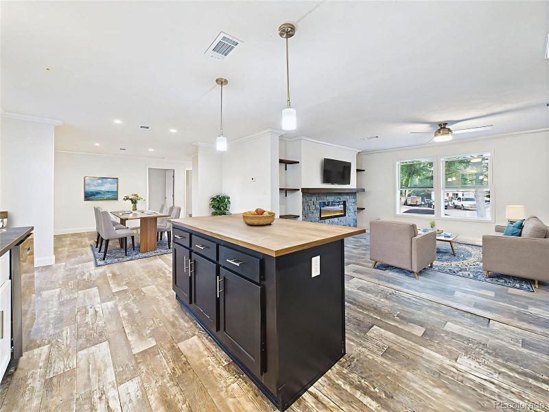 Virtually Staged images highlight seating at the island and open sightlines to the living room.