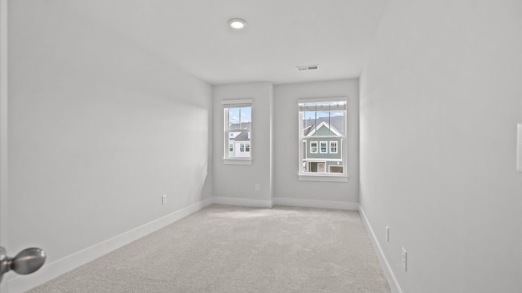 Vibrant and restful bedroom with oversized windows, refined detail, and a warm, welcoming atmosphere