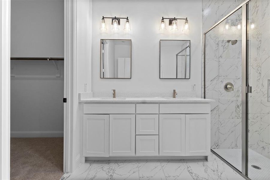 Bathroom with marble finish flooring, a marble finish shower, double vanity, and a walk in closet