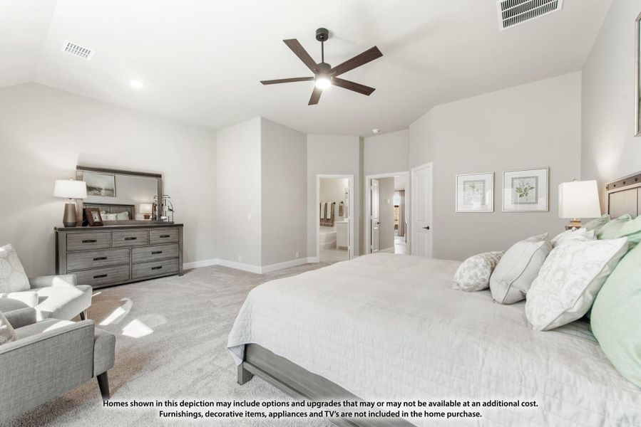 Spacious master bedroom with vaulted ceiling, ceiling fan, carpet flooring, and ensuite bathroom doorway visible.