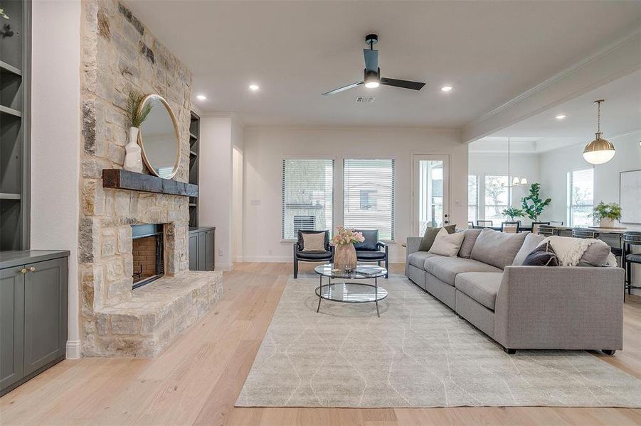 Living room with beautiful hardwood floors and 10 ft ceilings, fireplace with stone surround and cedar mantel.