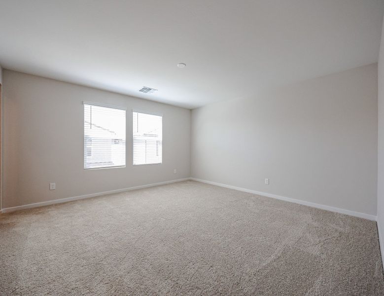 A room with a carpet and windows.