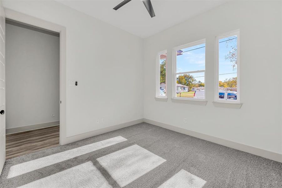 Unfurnished bedroom with light carpet and a ceiling fan