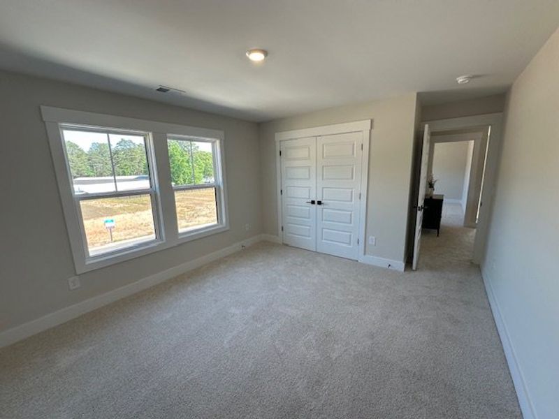 This bright bedroom features a spacious layout and