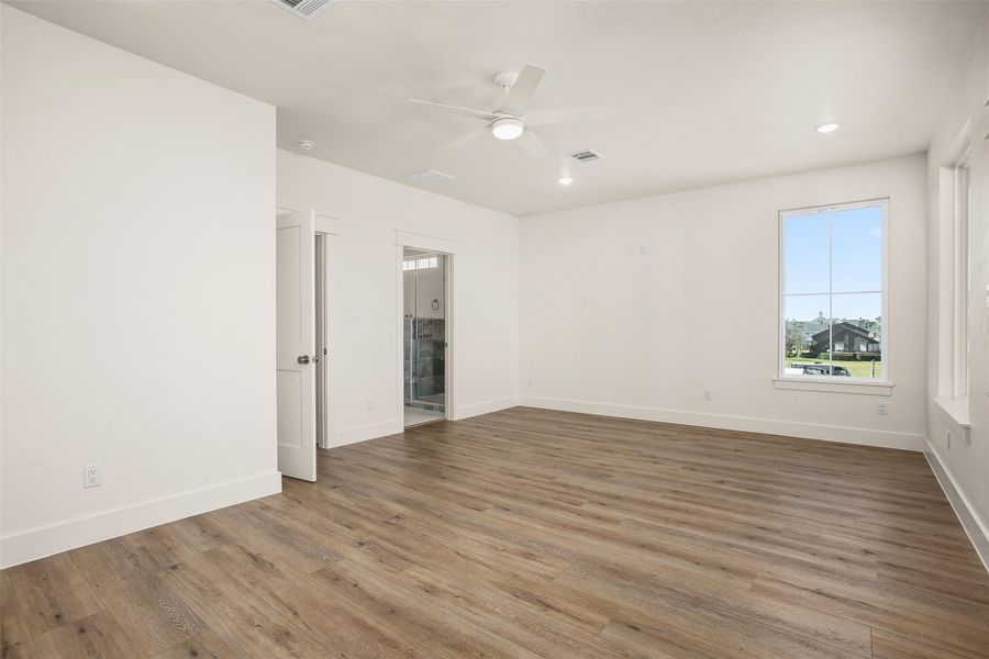 A second view of the primary bedroom with en suite bathroom