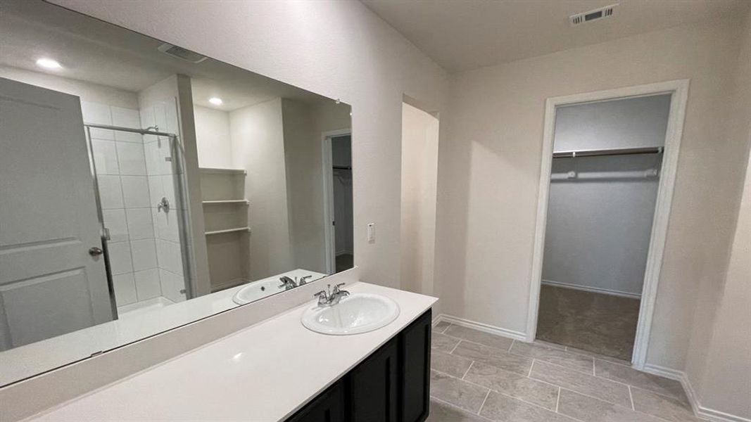 Bathroom vanity featuring a quartz-finish countertop, single basin sink, and ample mirror space Bathroom vanity featuring a quartz-finish countertop, single basin sink, and ample mirror space