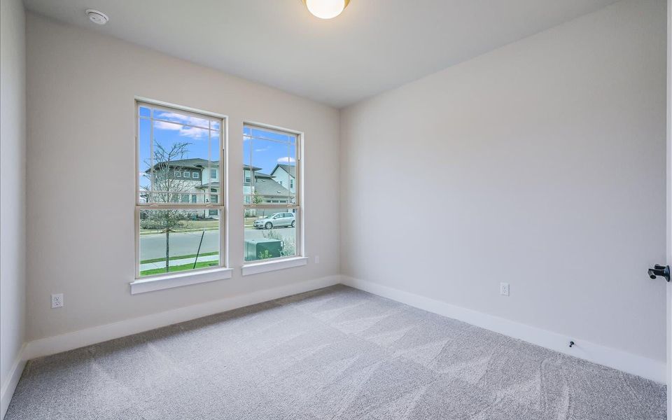 Empty room featuring light colored carpet and baseboards