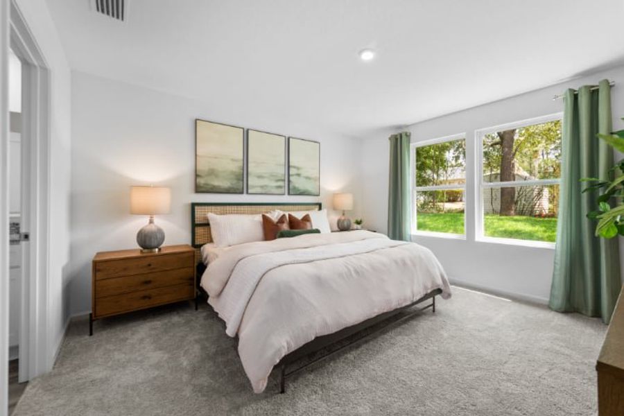 A bedroom with a large window.