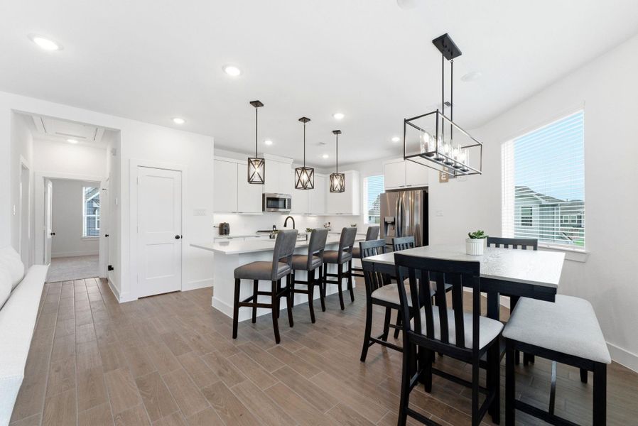 Stylish kitchen and dining area with generous island seating and large windows that fill the space with natural light.