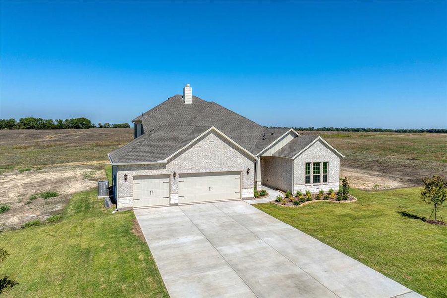 View of front of house with a garage and a front lawn