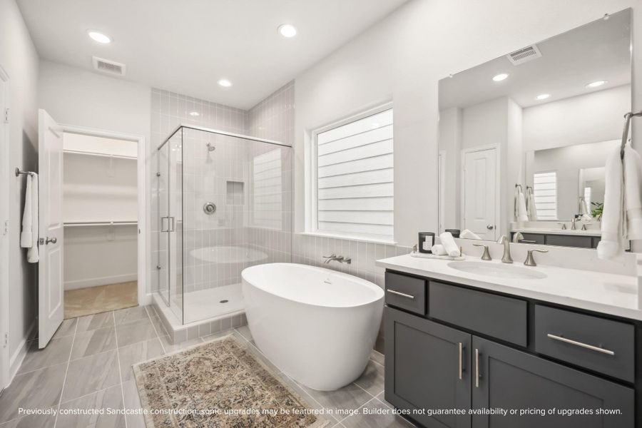 Indulge in a spa-like experience with a freestanding tub, step-in shower, dual sinks, a private water closet, and ample storage.