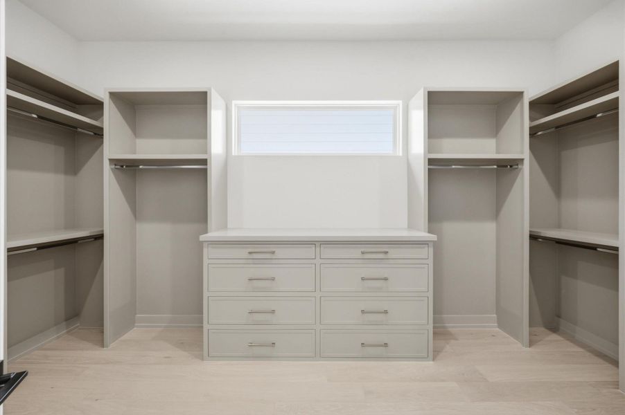 Well-appointed walk-in closet with custom cabinetry, generous storage and a built-in dresser.