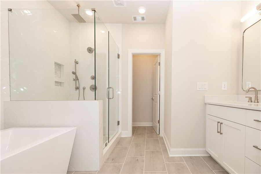 Our primary bathrooms either come with a separate walk in shower with frameless door and free-standing tubs or a larger walk in shower. Image is of previously built Chamberlain