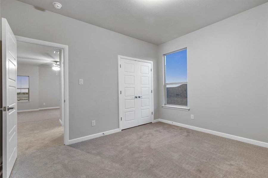 Unfurnished bedroom with multiple windows and light colored carpet