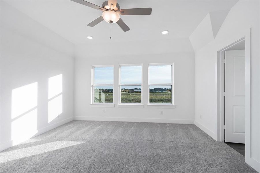 Carpeted empty room featuring ceiling fan