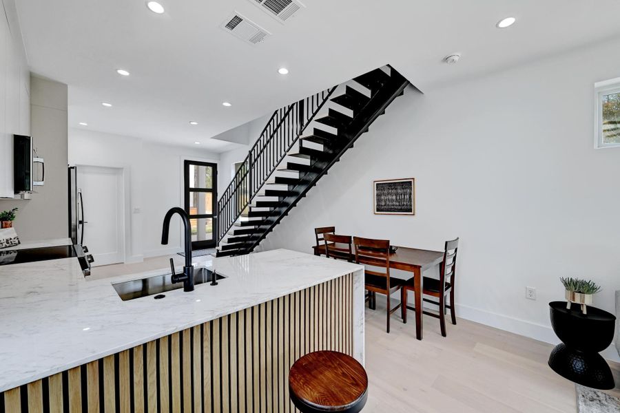 Kitchen with a peninsula, recessed lighting, light quartz countertops