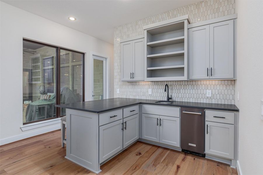 Built in cabinets provide storage in the functional wet bar and can easily serve outside guests through the door with direct access to the covered patio.