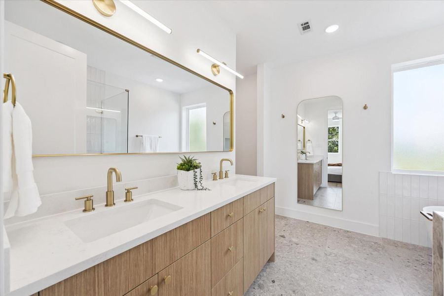 The primary bath will not disappoint with its dual bowl vanity, as well as copious amounts of counter, drawer and cabinet space. The floors here and in the other baths are porcelain. The primary bath will not disappoint with its dual bowl vanity, as well as copious amounts of counter, drawer and cabinet space. The floors here and in the other baths are porcelain.