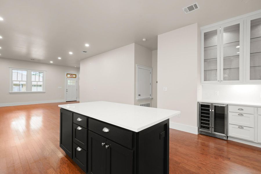 A contemporary kitchen island with white countertops anchors this luminous open-concept living space. A contemporary kitchen island with white countertops anchors this luminous open-concept living space.