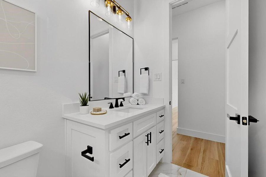 Half bath featuring vanity and light wood-type flooring Half bath featuring vanity and light wood-type flooring