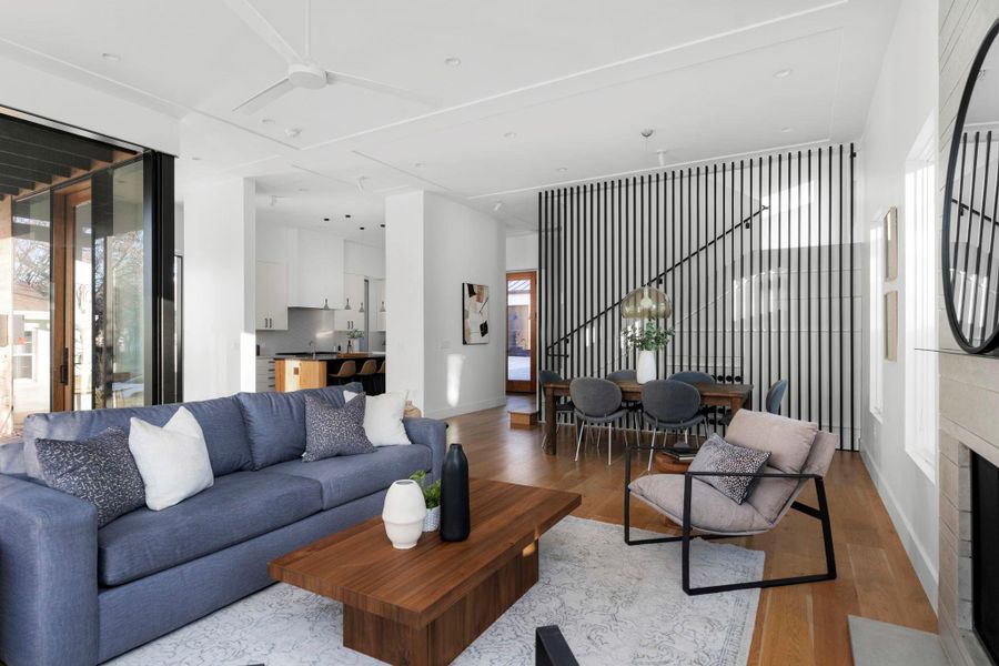 Living area featuring wood finished floors, ceiling fan, and a tile fireplace