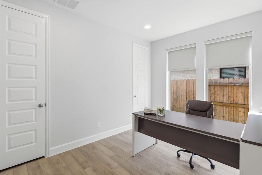 Perfect for working from home, this private study offers beautiful natural light, durable wood-look tile flooring, and a flexible layout with room for a full executive desk and additional furnishings. A nearby closet adds convenient storage.