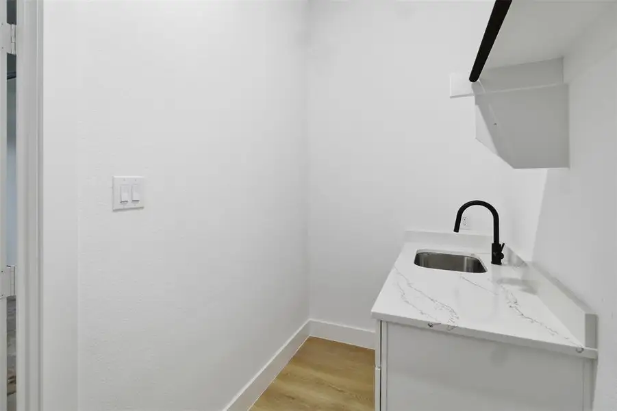 Washroom featuring a sink and light wood finished floors