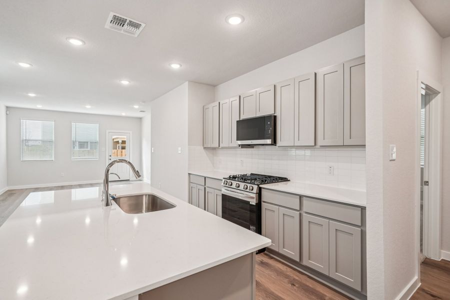 A kitchen with white cabinets.