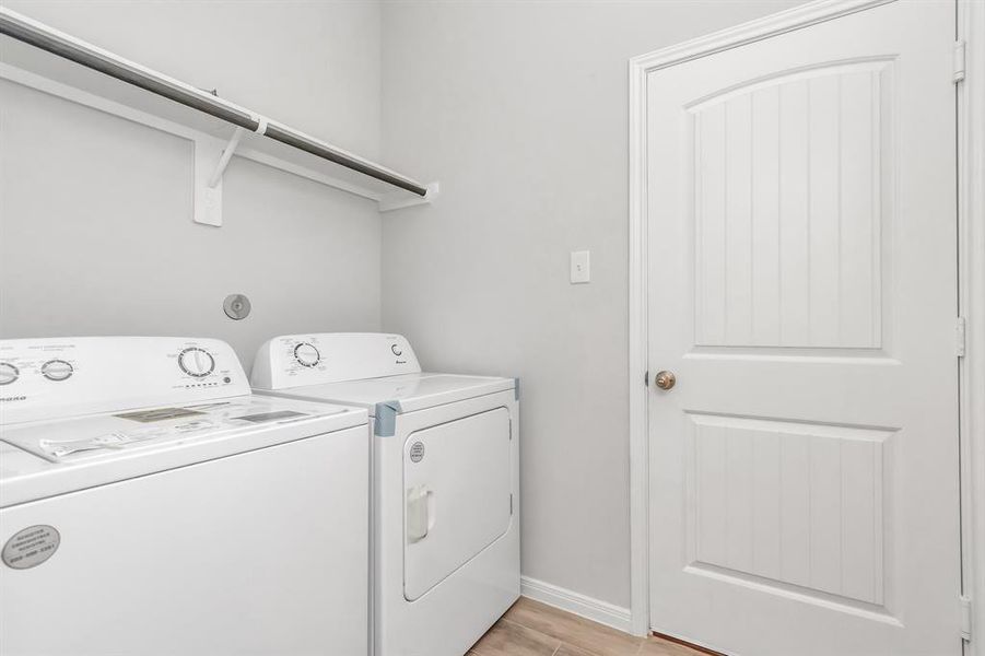 Convenience meets practicality in this well-appointed laundry room, equipped with modern washer and dryer units. The ample shelf space and sleek design ensure that laundry day is as efficient as possible. The neutral tones and clean lines complement the home's overall aesthetic, providing a functional and stylish space. **This image is from another Saratoga Home - Wren floorplan.**