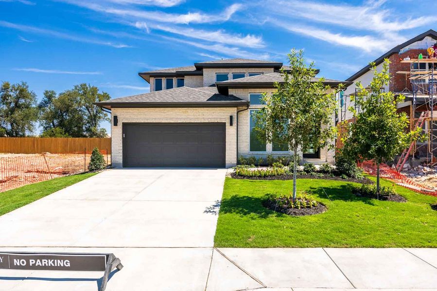 View of front facade featuring brick siding, concrete driveway, a garage, and a shingled roof View of front facade featuring brick siding, concrete driveway, a garage, and a shingled roof