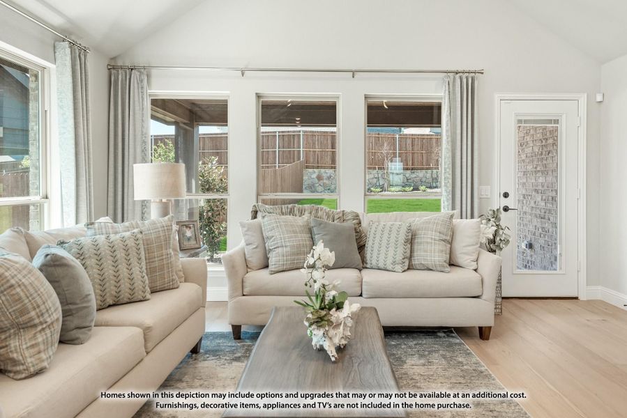 Living room with two beige sofas, wood coffee table, and large windows overlooking a backyard patio. Living room with two beige sofas, wood coffee table, and large windows overlooking a backyard patio.