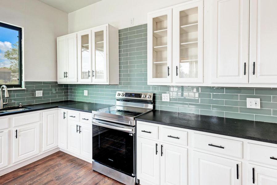 White shaker cabinets pair seamlessly with dark countertops and a sleek subway tile backsplash.
