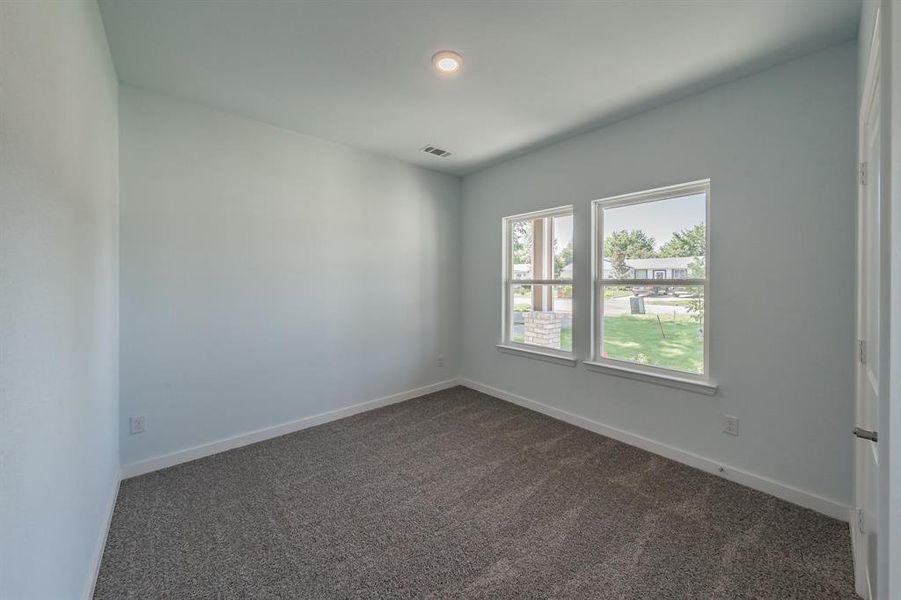 Unfurnished room with dark carpet and baseboards Unfurnished room with dark carpet and baseboards