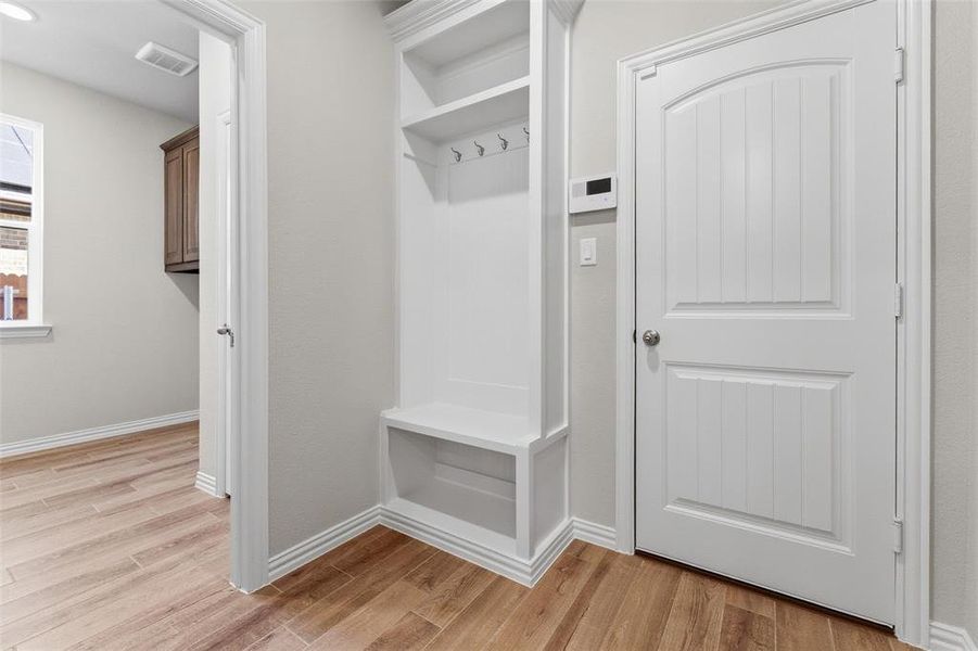 Mudroom with light wood-style flooring and baseboards