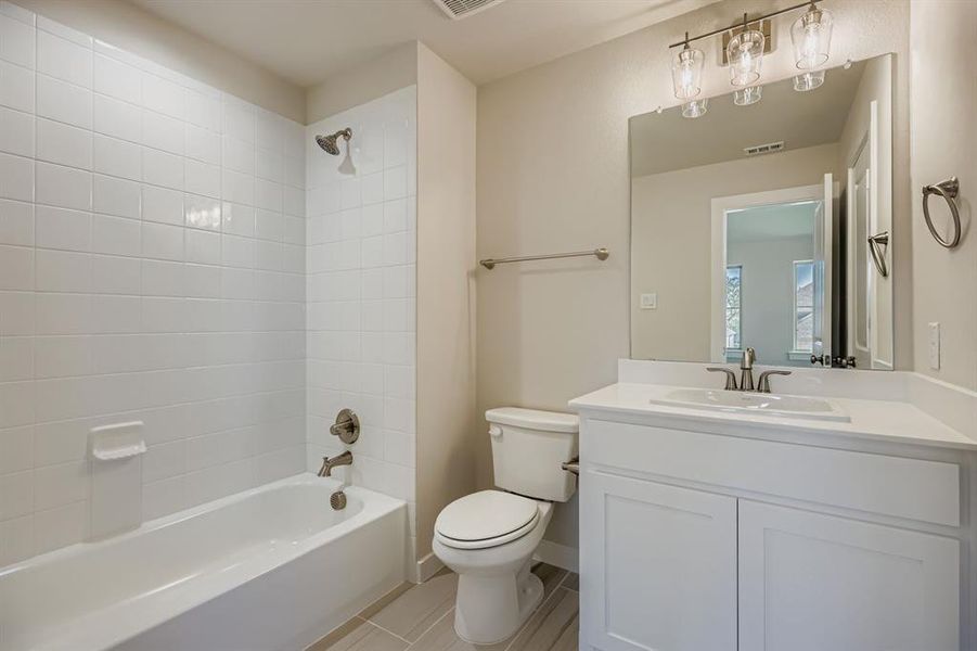 Full bath with shower / bathtub combination, vanity, and light tile patterned floors