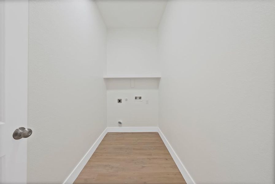 Washroom with light wood-style floors, hookup for an electric dryer, and hookup for a washing machine