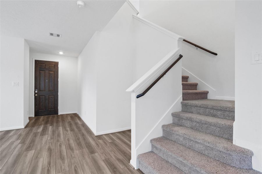 Step inside your new home, where the Layton Lake vinyl plank flooring and fresh, bright paint create a warm and inviting entryway.