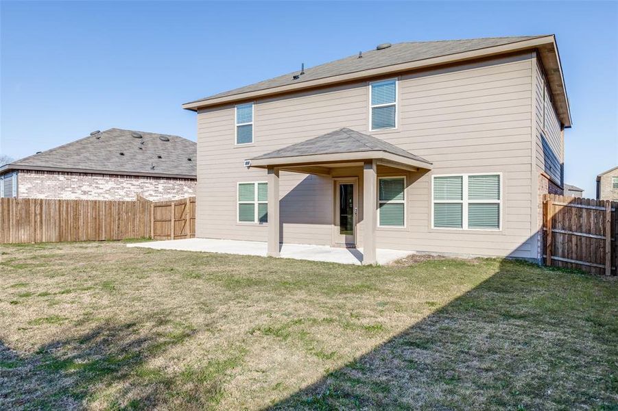 Back of property with a yard and a patio