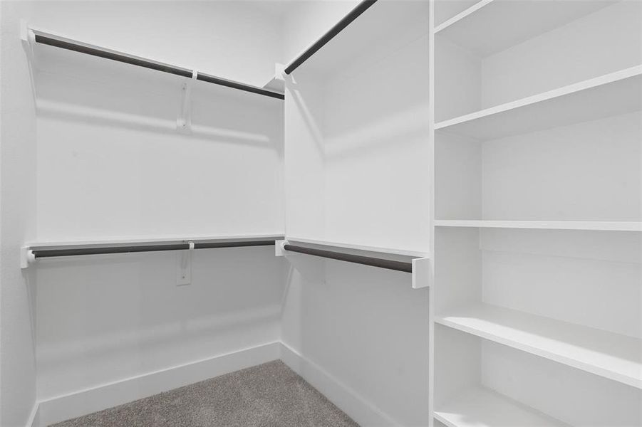 Walk in closet with light colored carpet