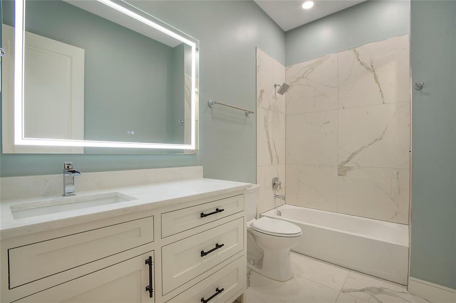 Bathroom with vanity, light marble finish floors, and shower / bath combination