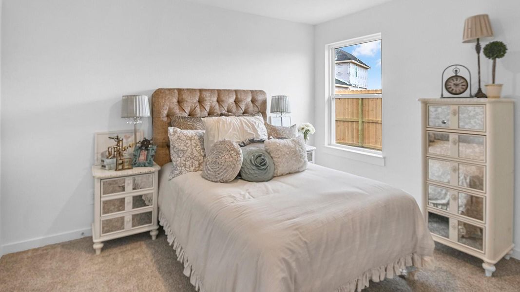 Comfortable guest bedroom featuring neutral-toned walls, carpeted flooring, and a separate closet.