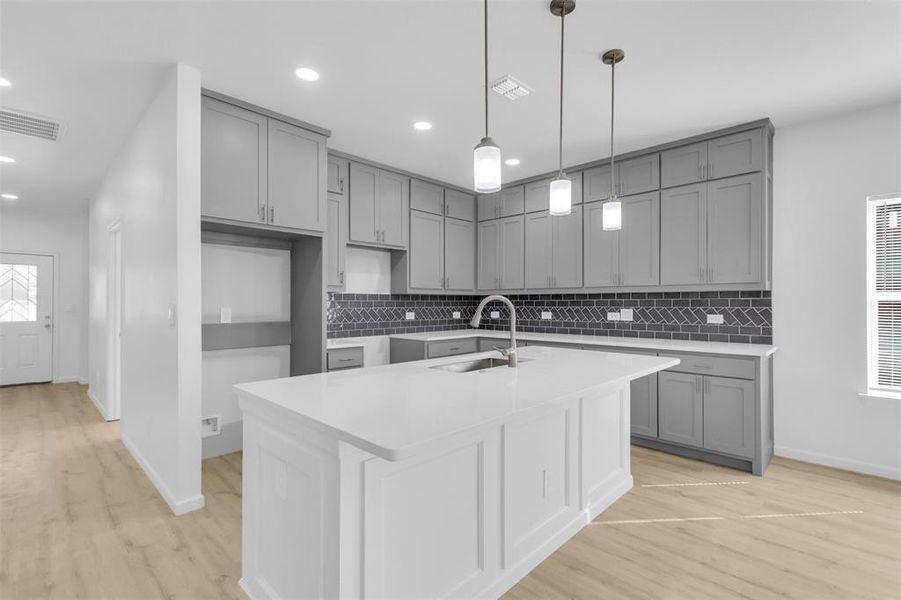 Kitchen featuring gray cabinets, tasteful backsplash, light wood-style floors, light stone counters, and recessed lighting
