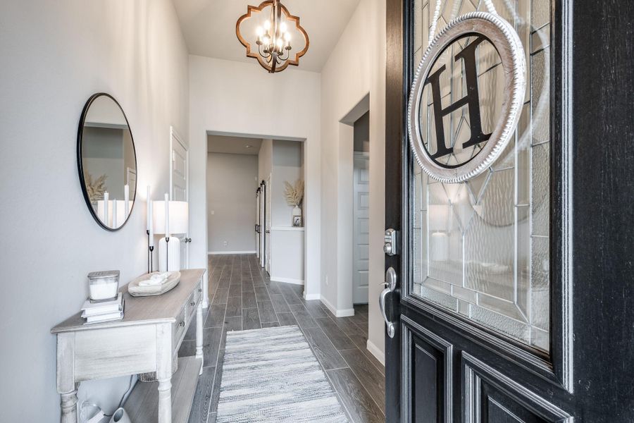 This welcoming entryway features a stylish door with glass detailing, leading into a bright hallway. Elegant lighting, complemented by wood-look flooring and neutral walls. This welcoming entryway features a stylish door with glass detailing, leading into a bright hallway. Elegant lighting, complemented by wood-look flooring and neutral walls.